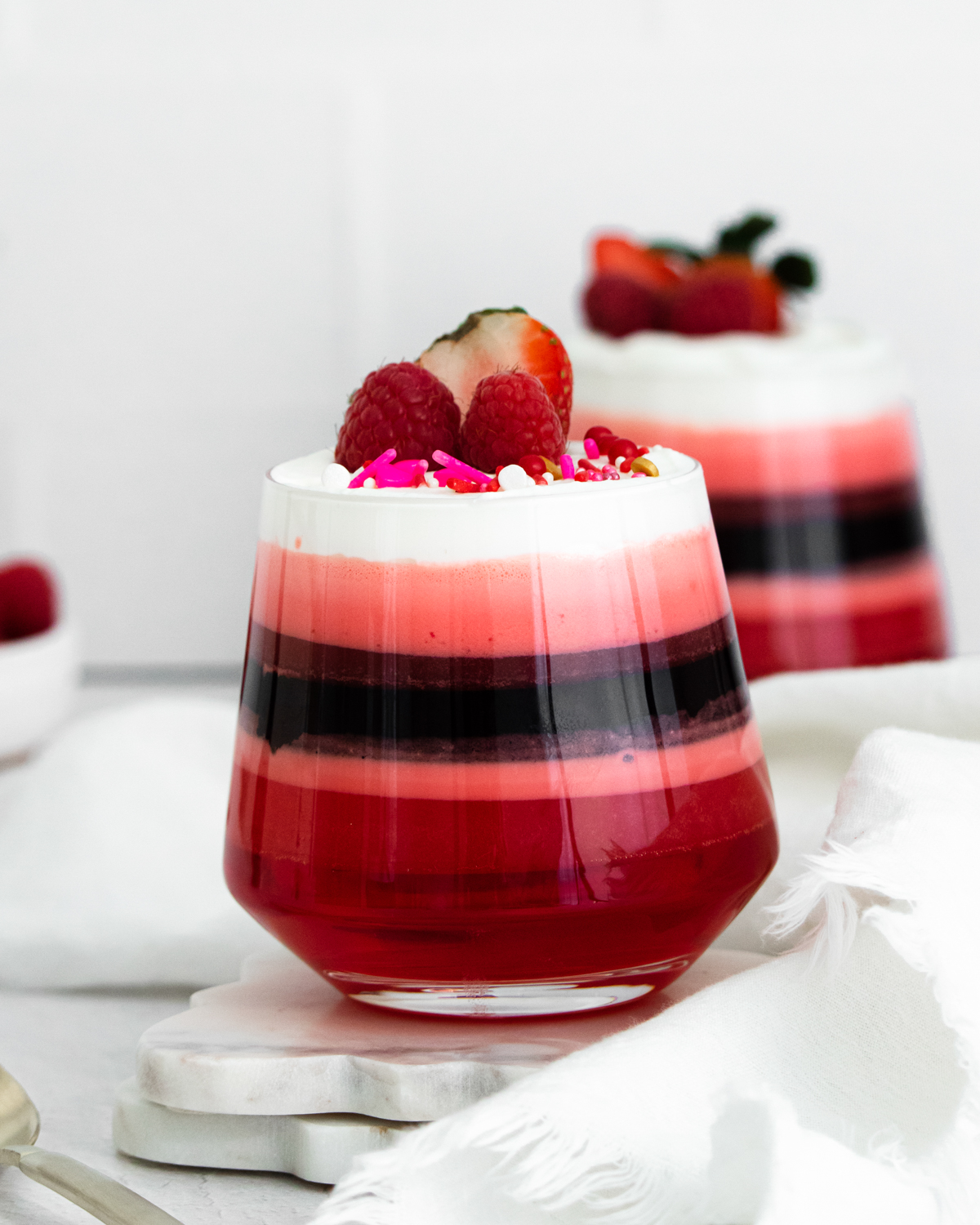 a glass filled with a layered jello dessert for Valentine's Day