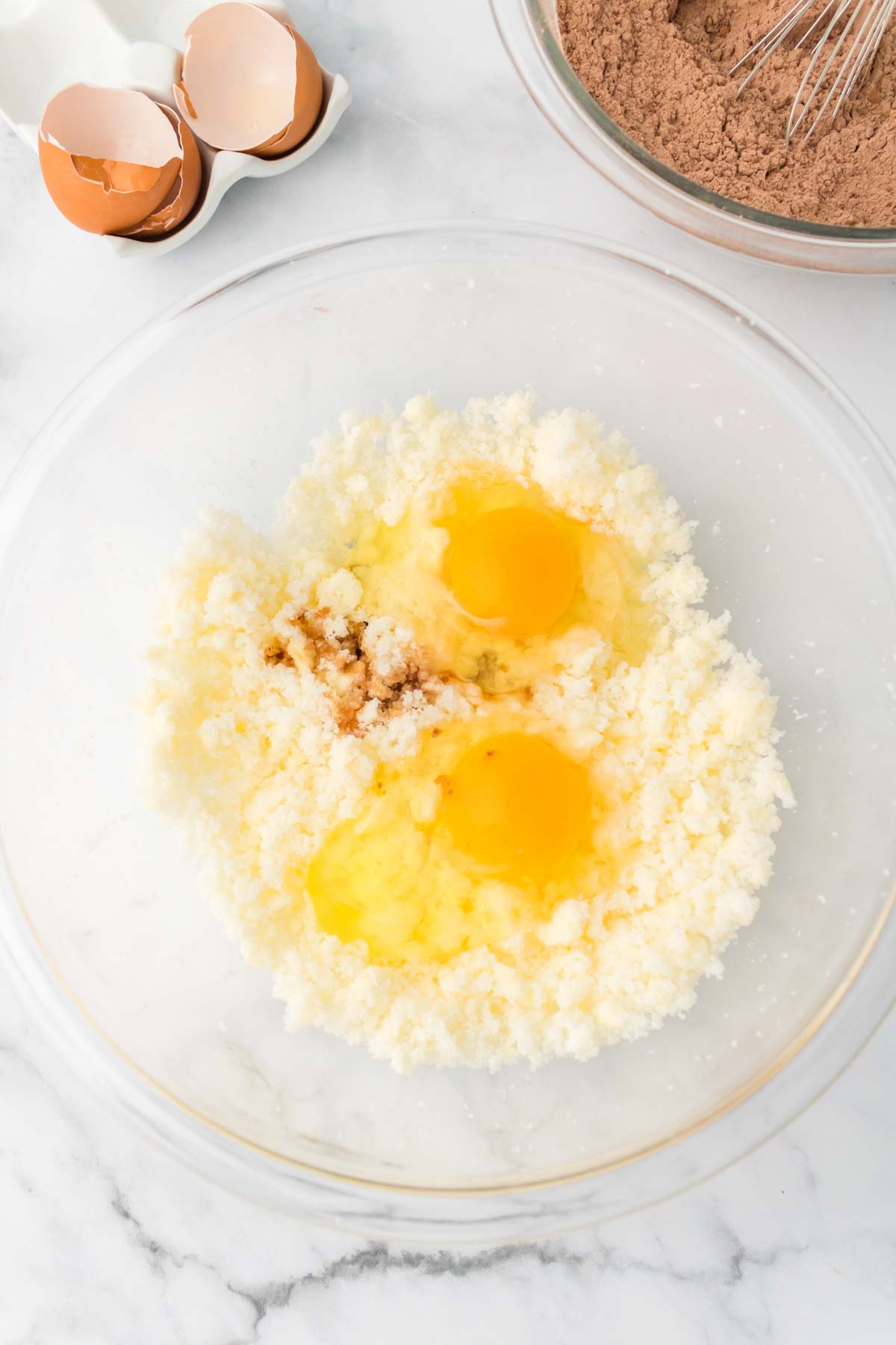 glass bowl with buttery sugar mixture and eggs