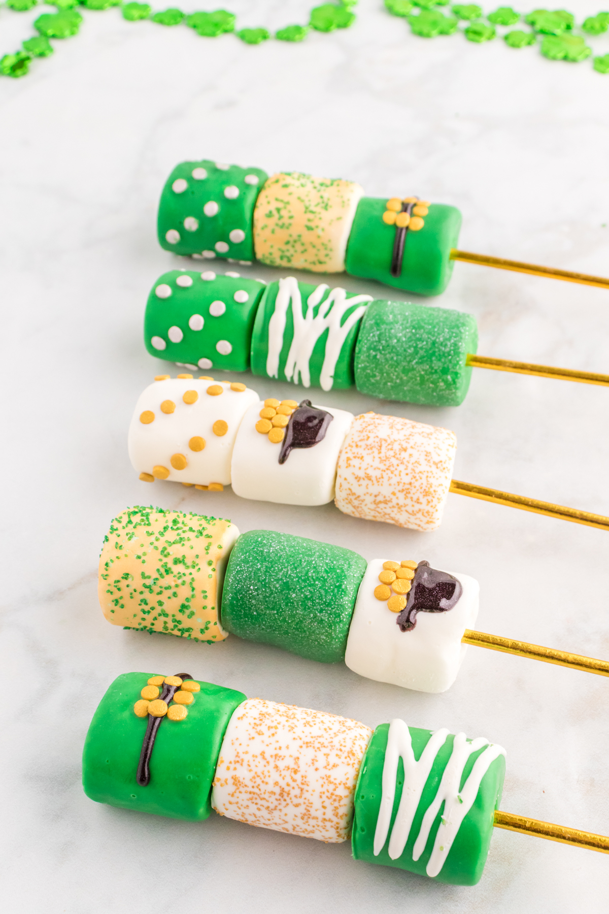 St. Patrick's Day marshmallow pops drying on parchment paper