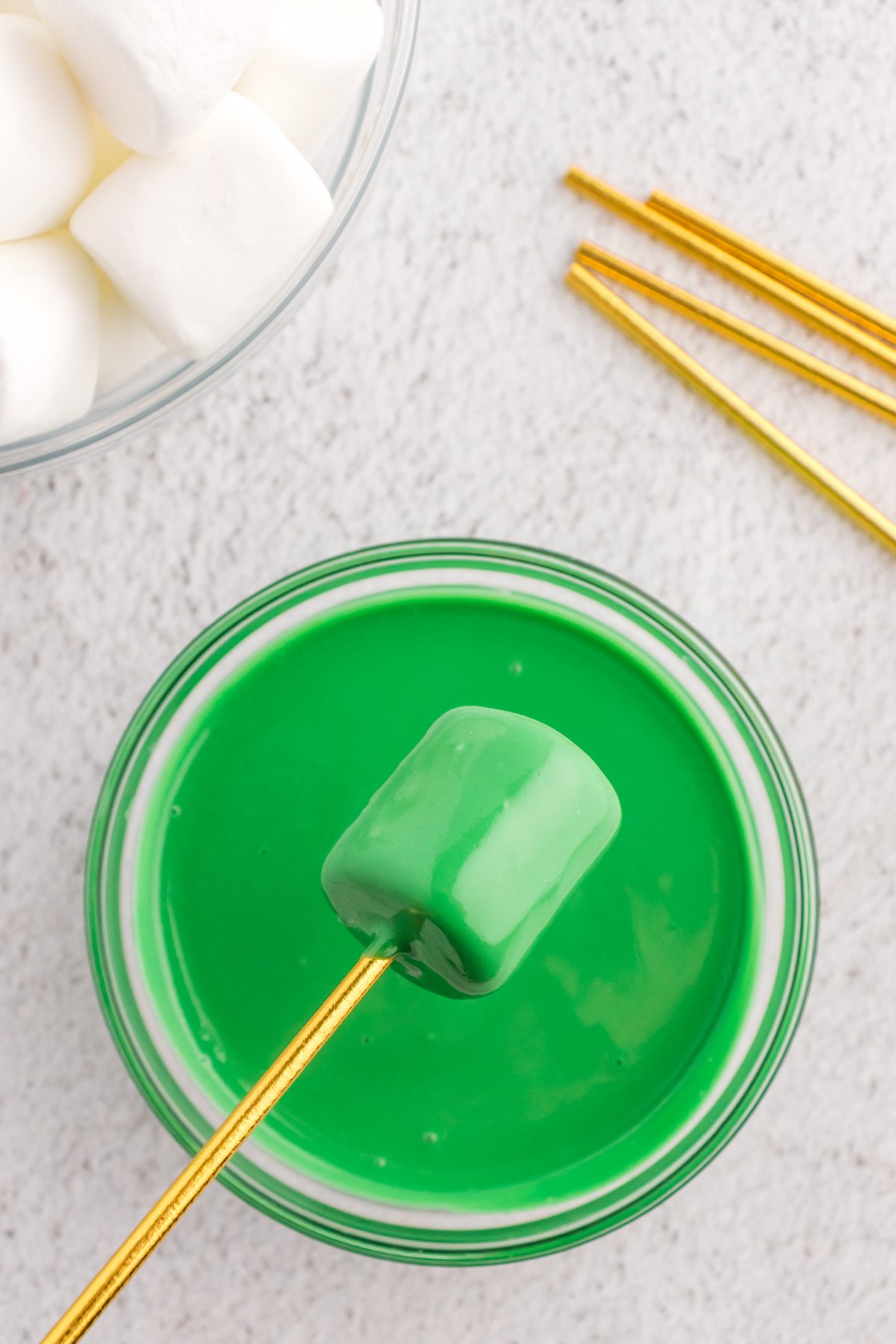 marshmallow dipped on a stick and dipped in green candy melt