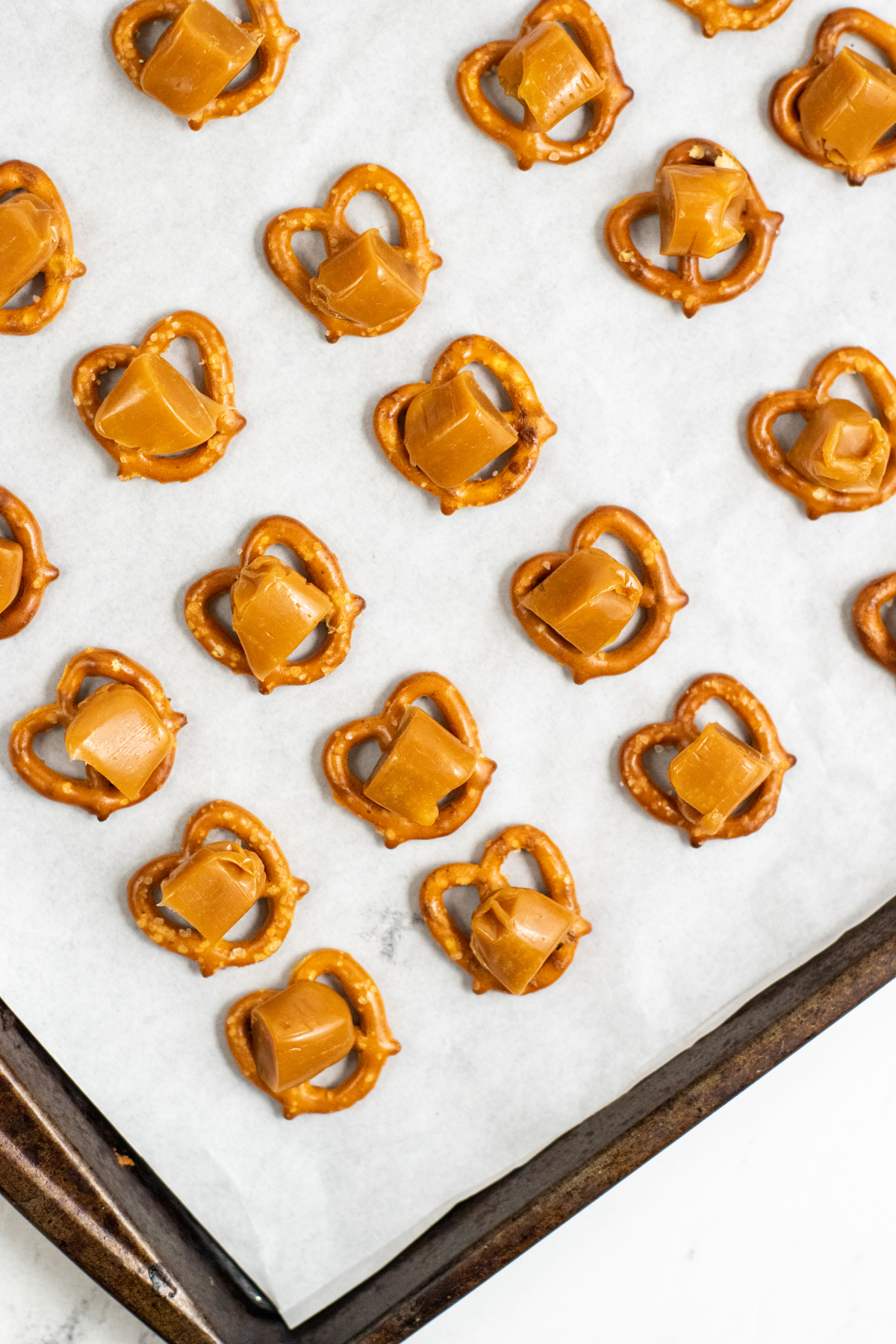 pretzels on a baking sheet topped with caramels