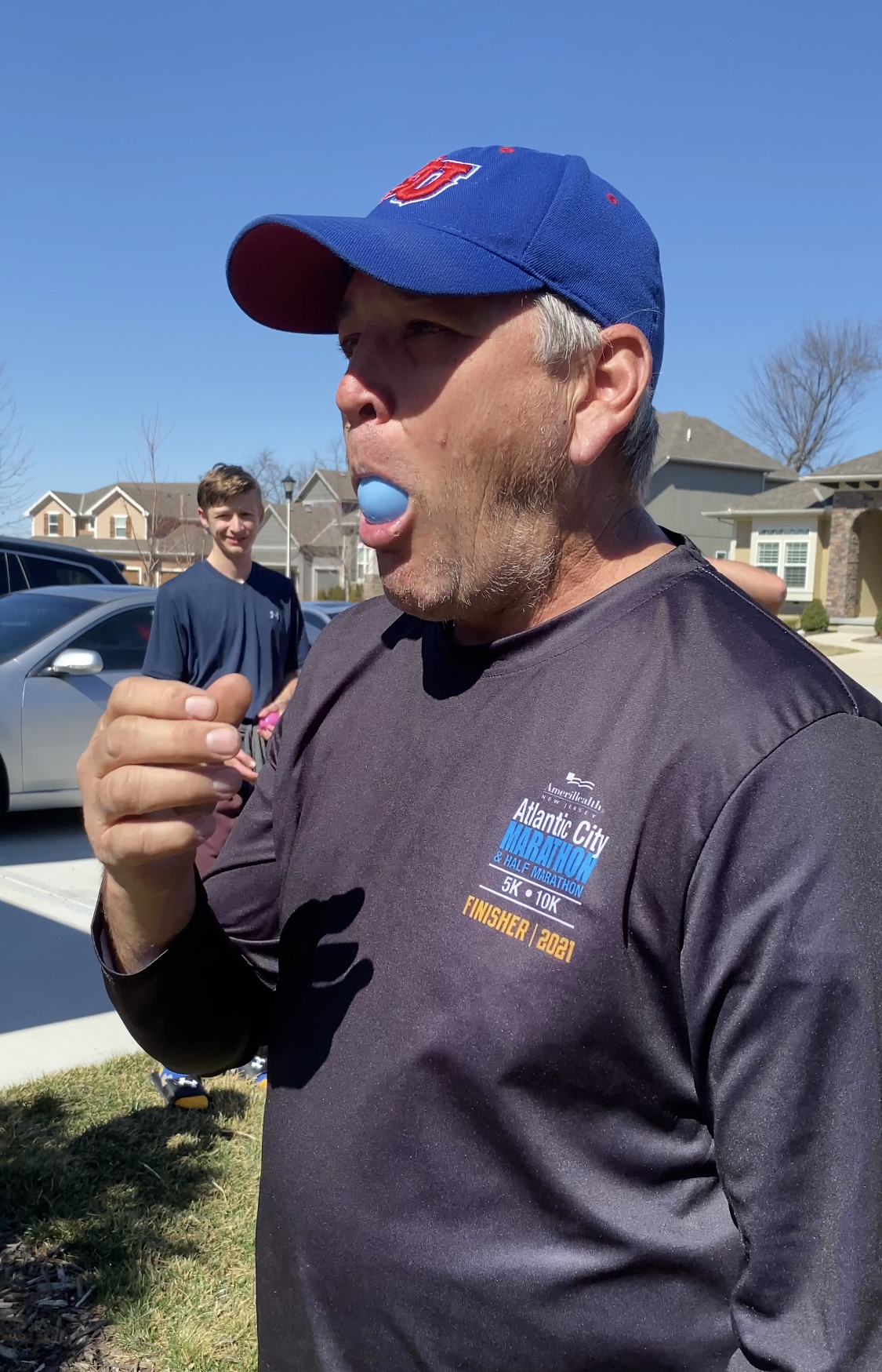 man with a plastic Easter egg in his mouth