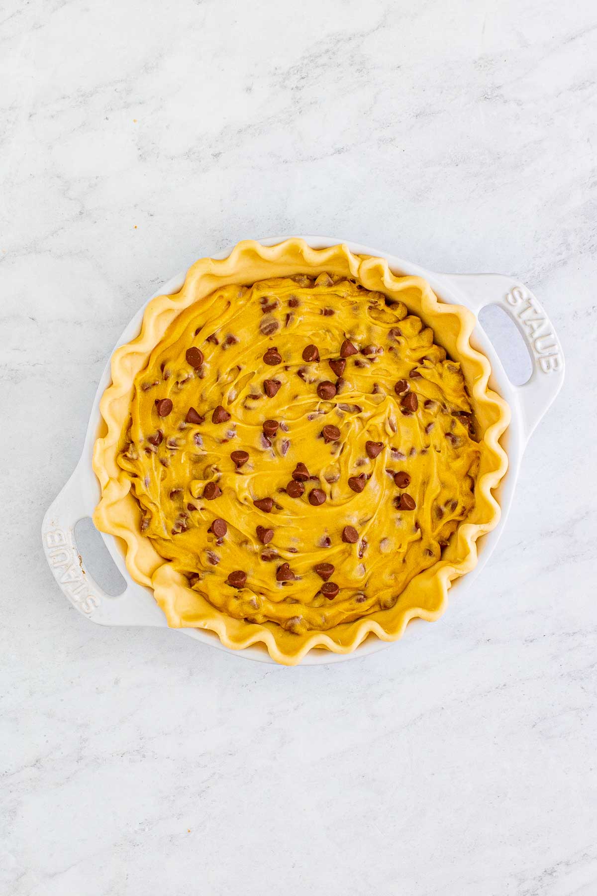 pie pan with unbaked chocolate chip cookie pie 
