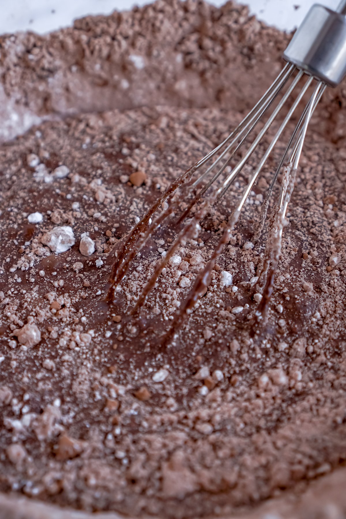 chocolate glaze with a whisk in a glass bowl