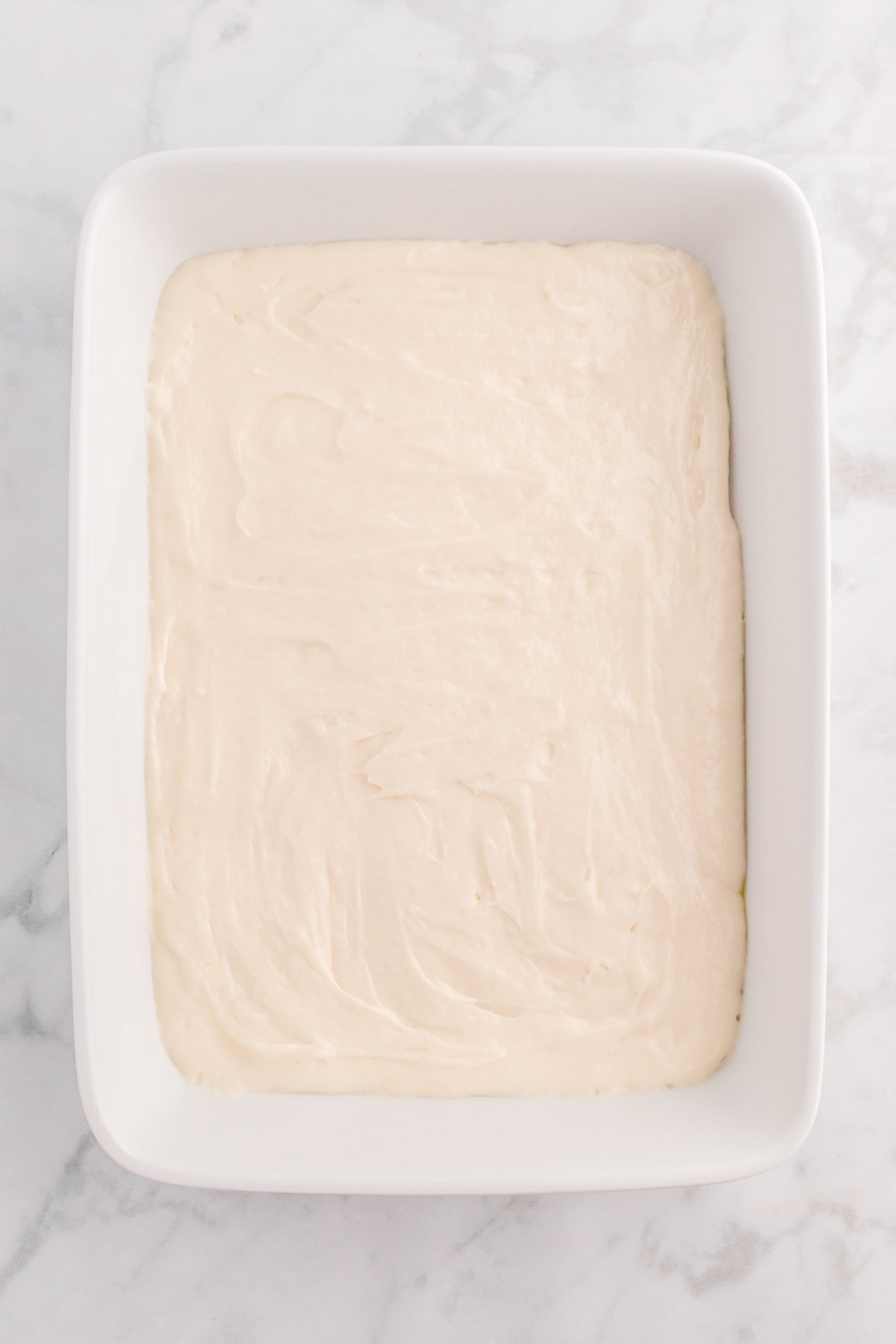 white baking dish with white cake batter
