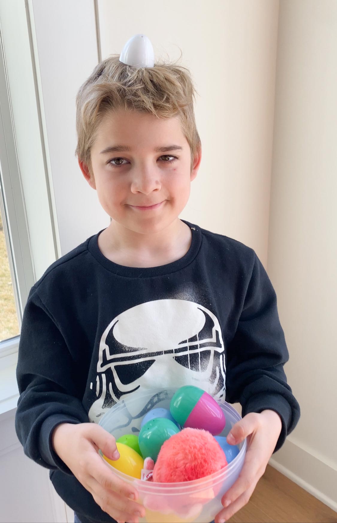 kid holding a basket of Easter eggs