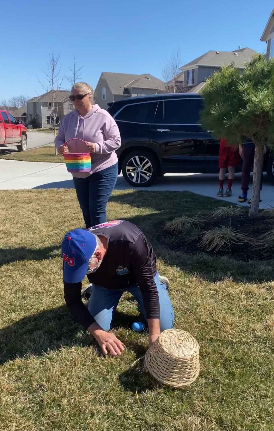 dad on the ground searching in an Easter egg hunt