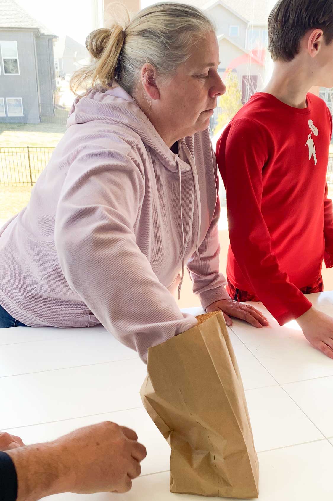 woman with hand in a brown paper bag