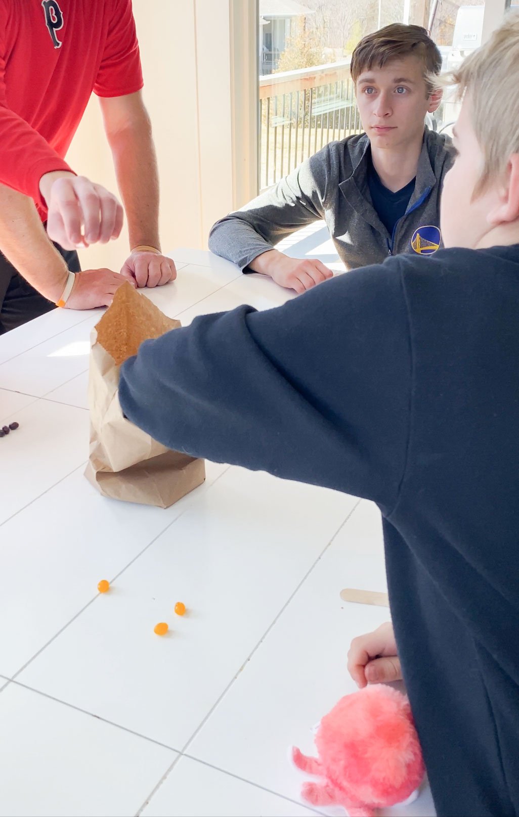 kid pulling jelly beans out of a paper bag