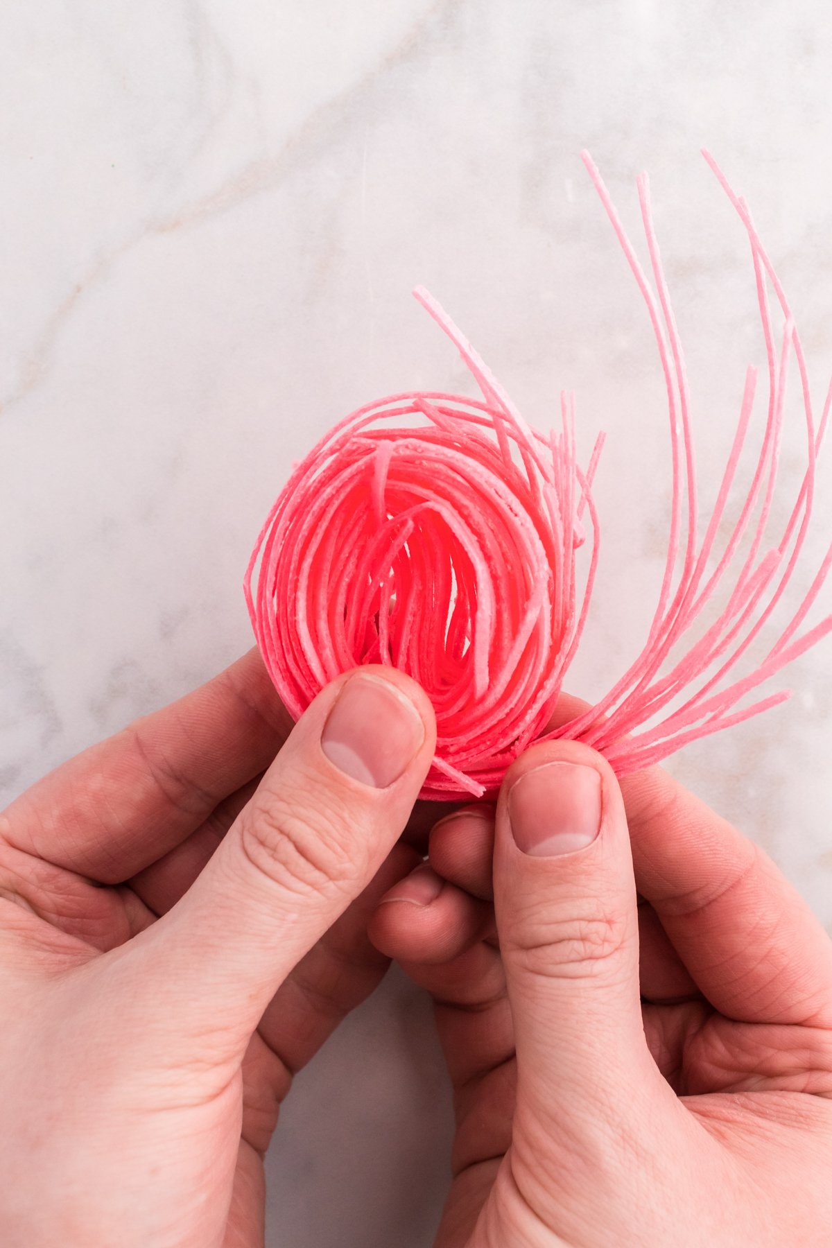 hands rolling candy grass into nests