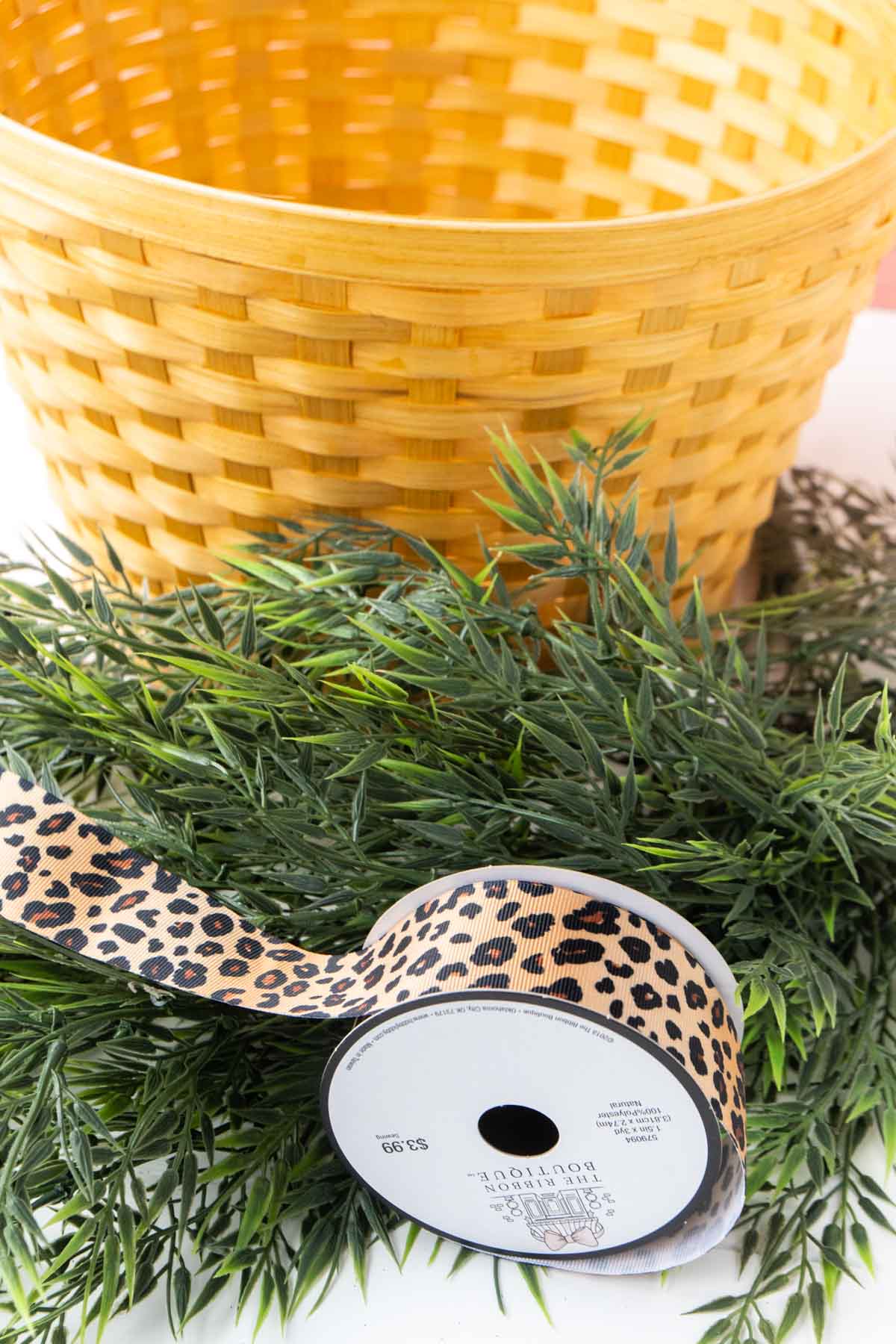 yellow basket with greenery and leopard ribbon