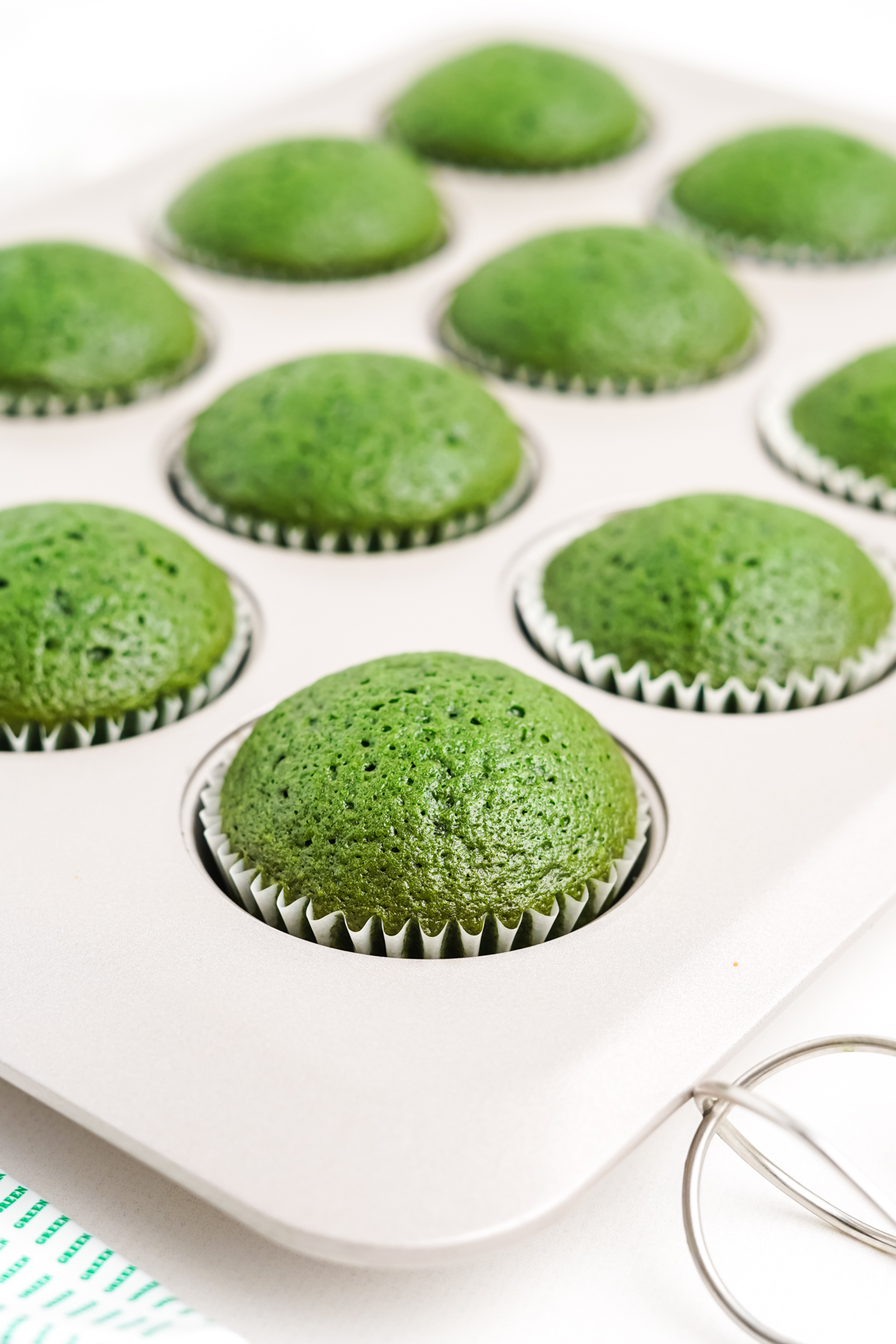 muffin tin with baked green velvet cupcakes 
