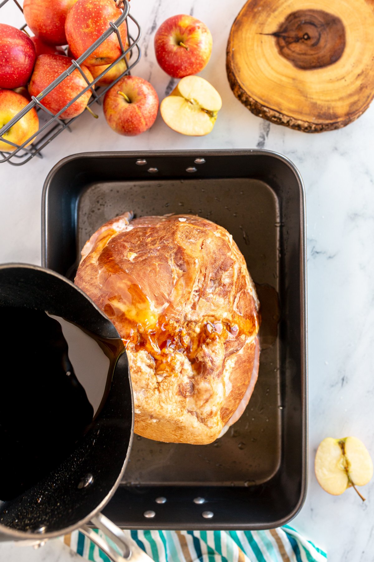 pouring apple cider over a ham