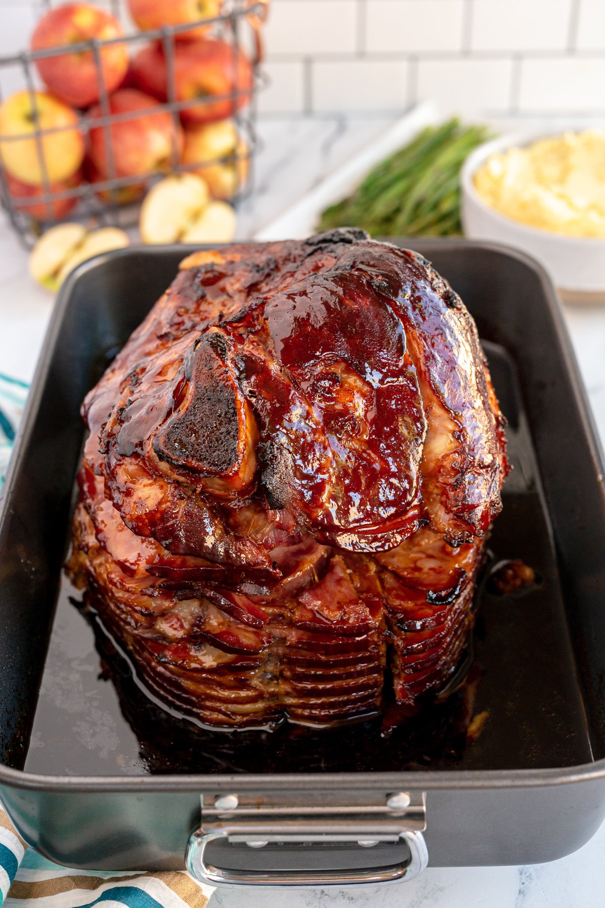 large baking pan with a baked glazed ham inside