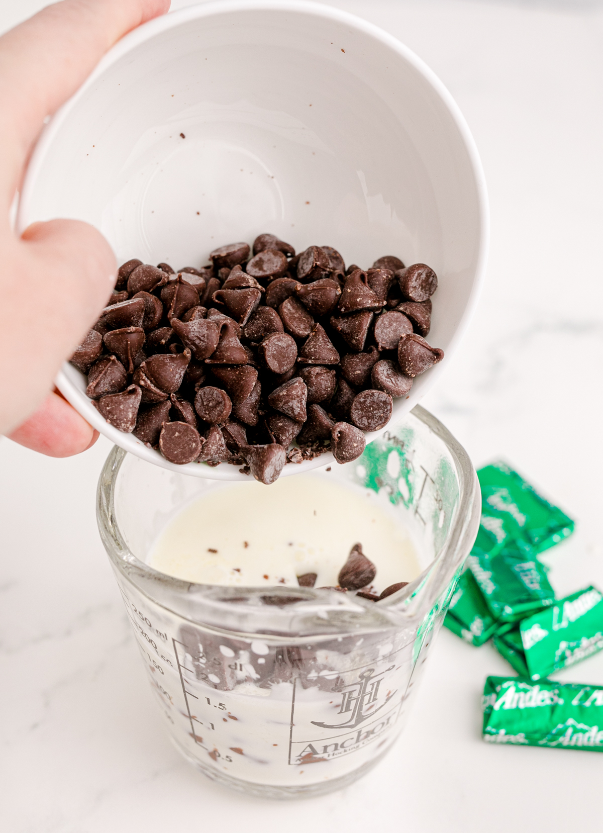 pouring chocolate chips into heavy cream