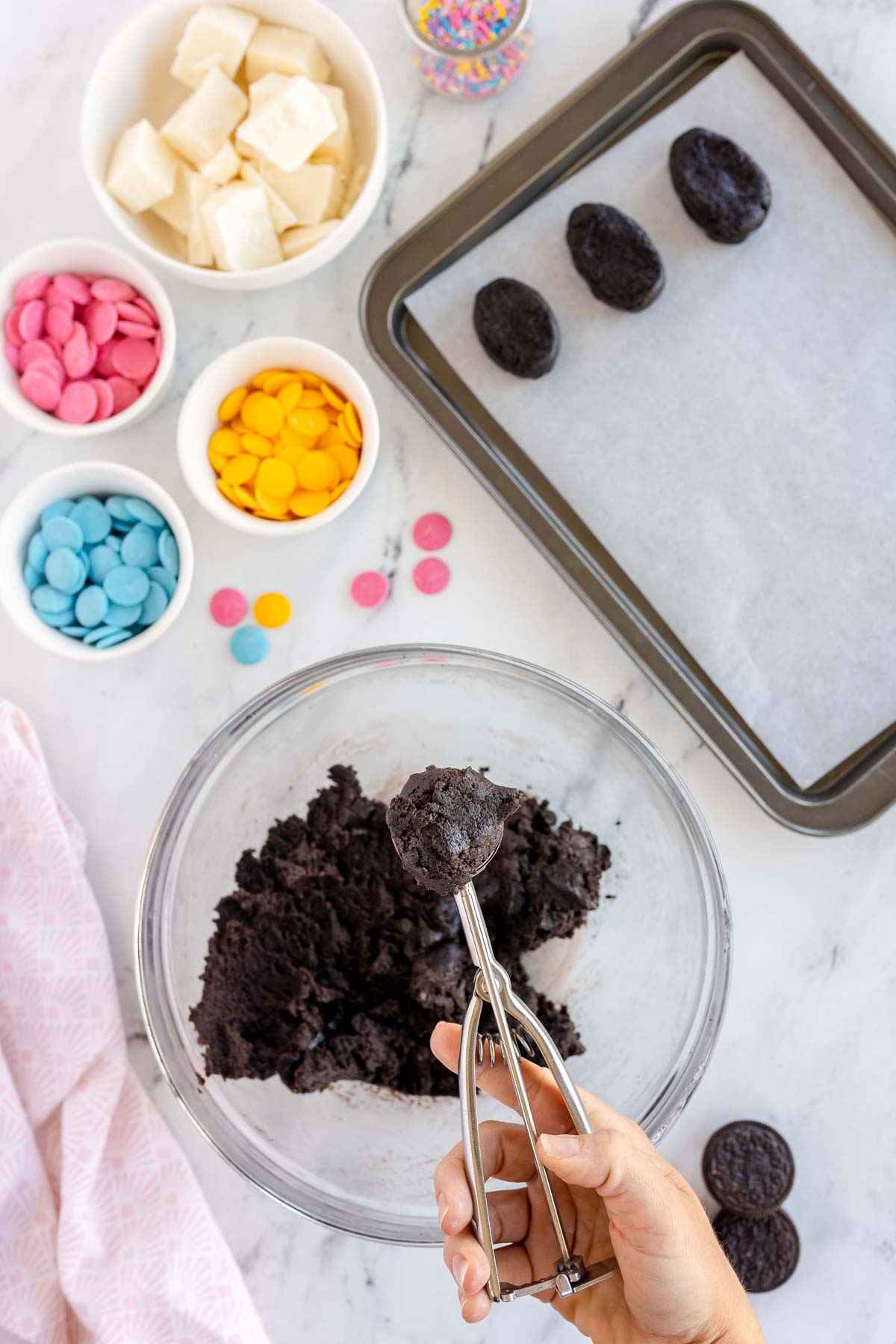 scooping Oreo truffle mixture in a cookie scoop