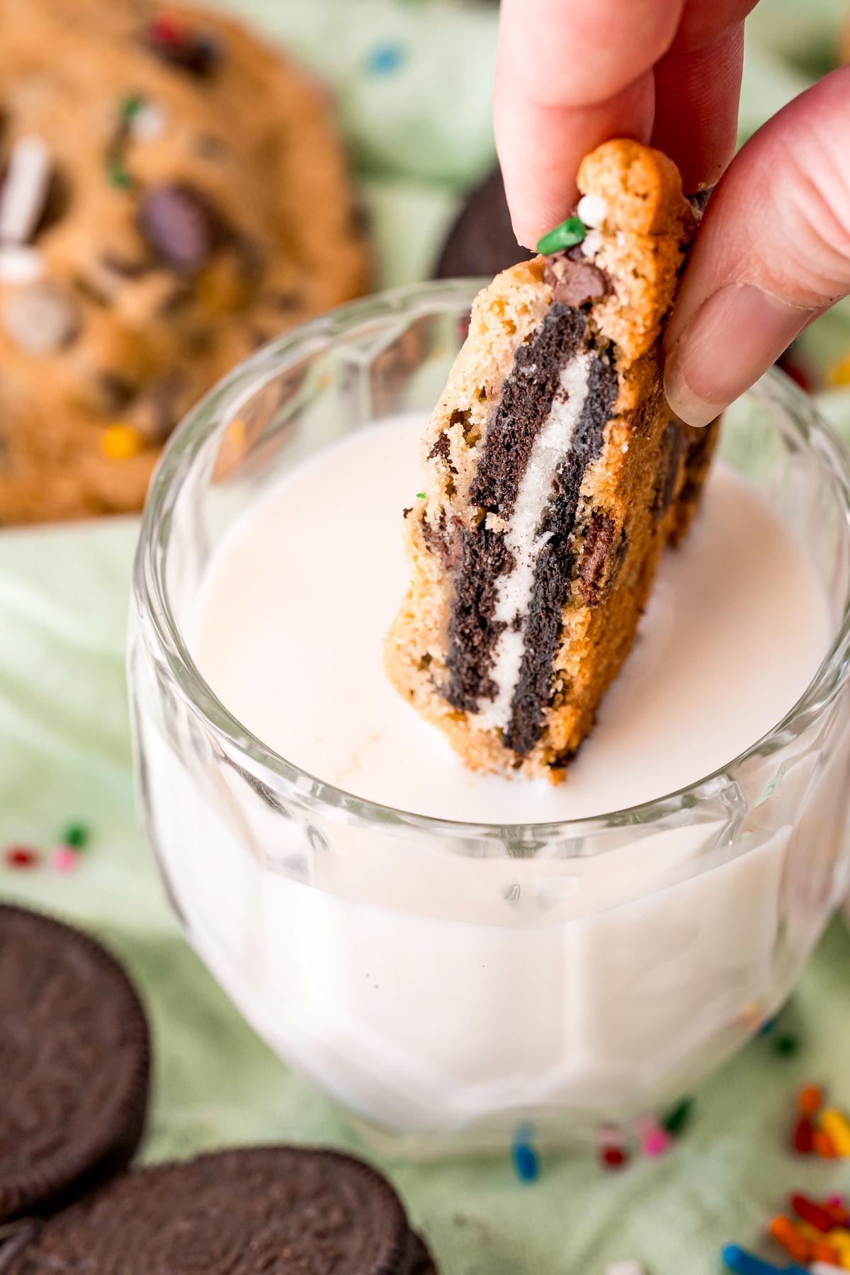 Oreo stuffed cookie being dunked in a glass of milk