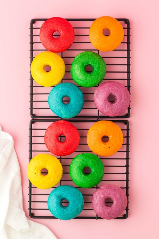 baked rainbow donuts cooling on a wire rack