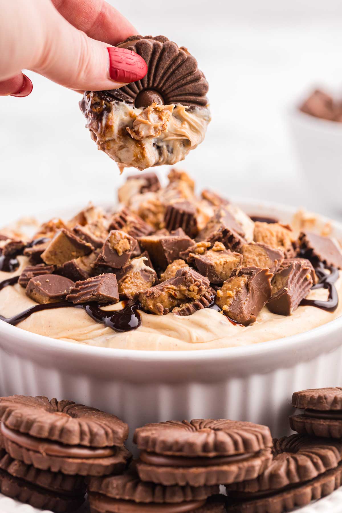 hand holding a cookie over a Reese's peanut butter cup