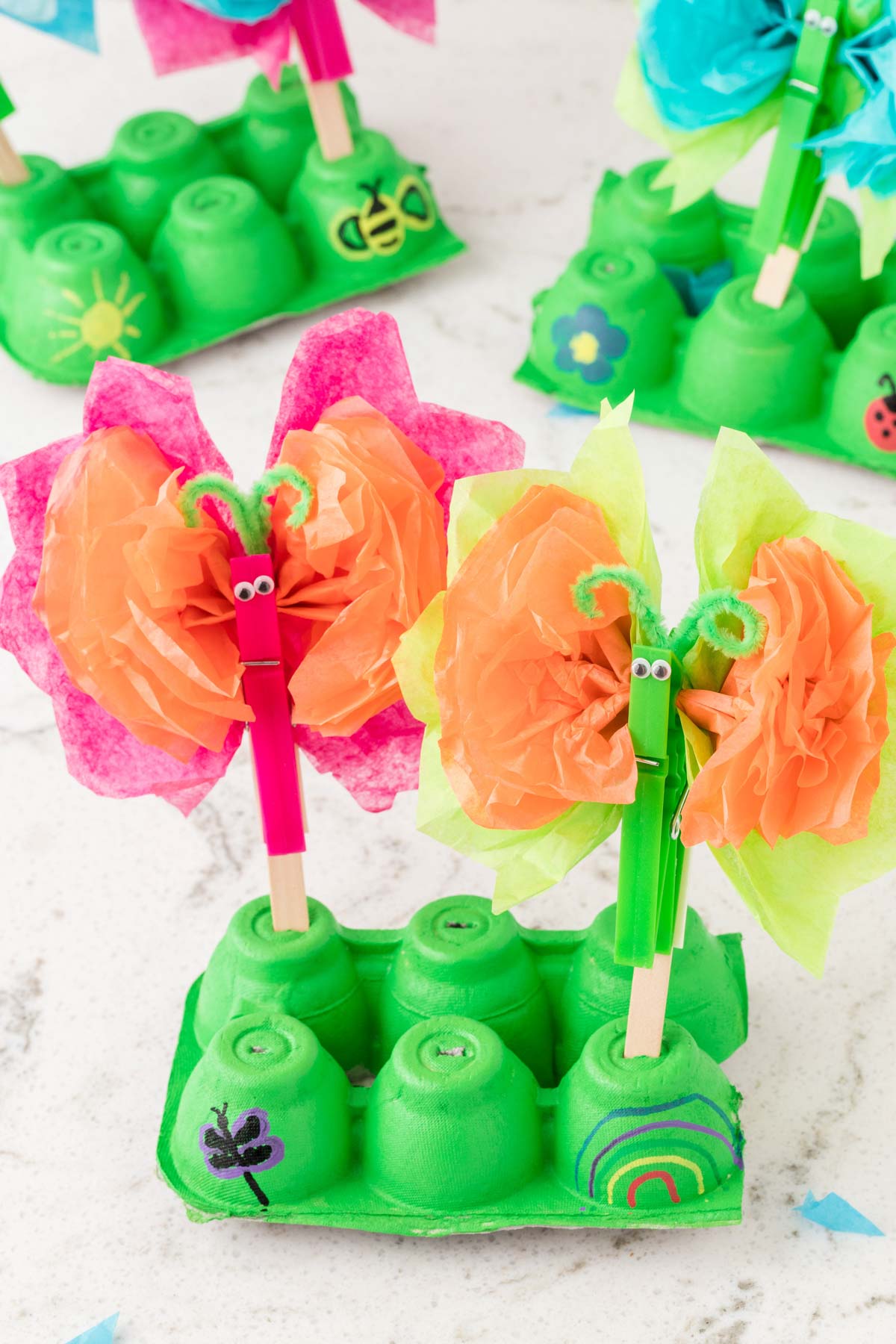 tissue paper butterflies on a green egg carton