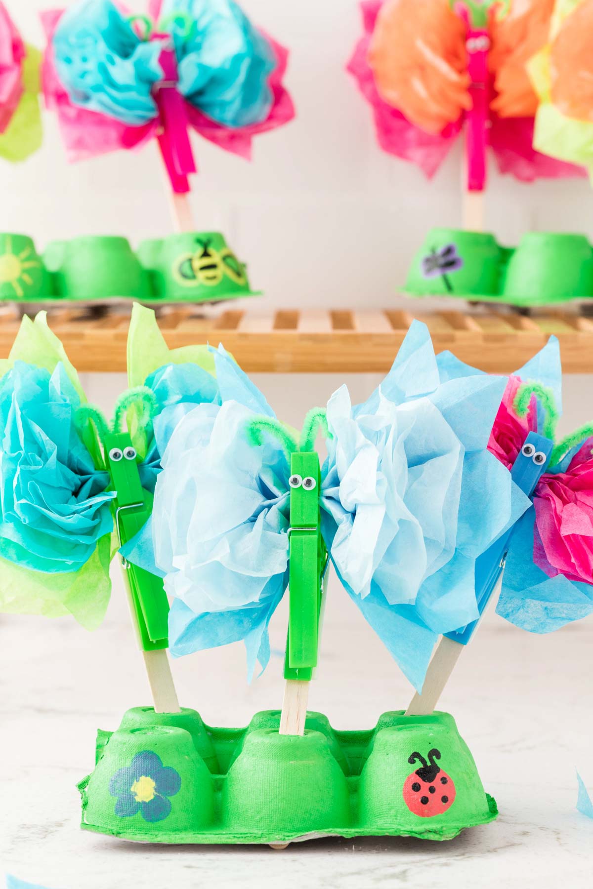 tissue paper butterflies stuck into a green egg carton