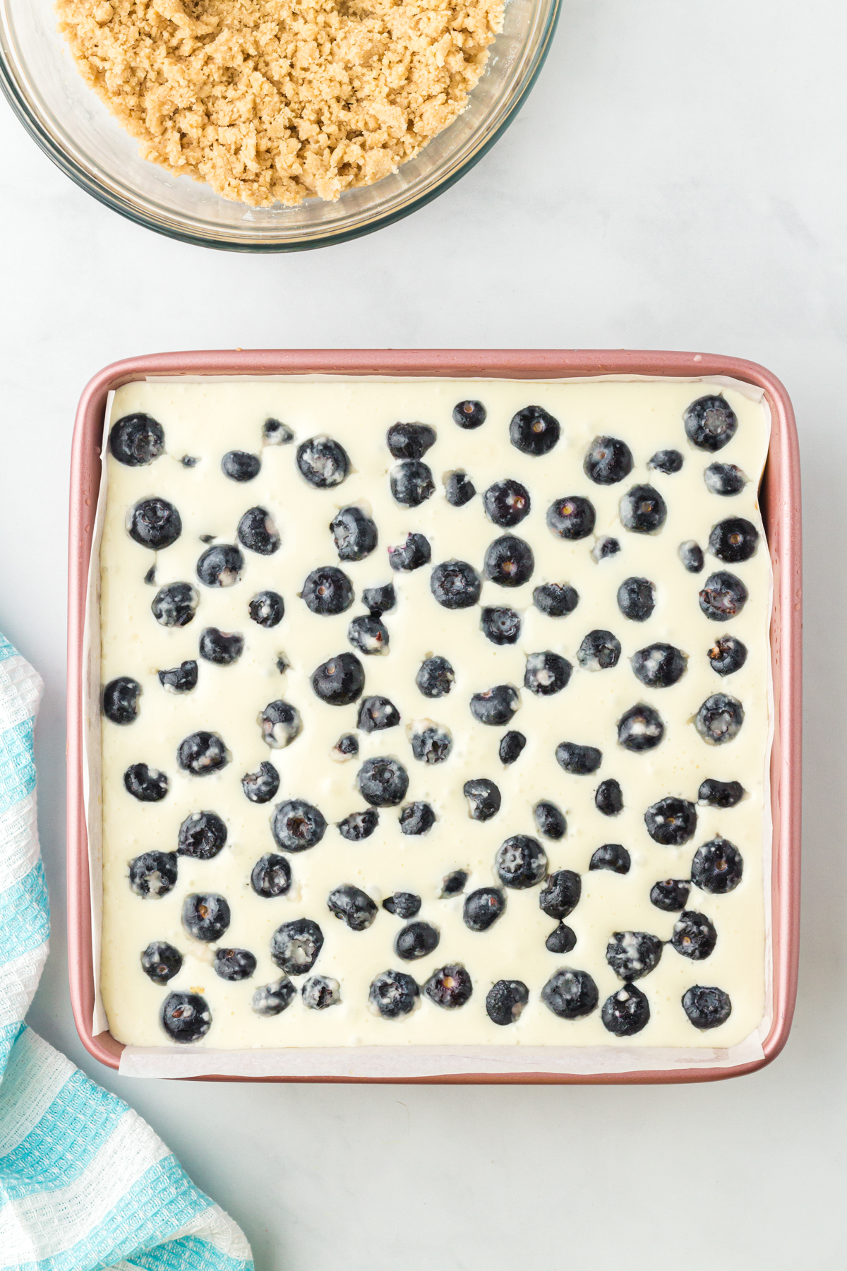 unbaked blueberry cheesecake bars in a square pan