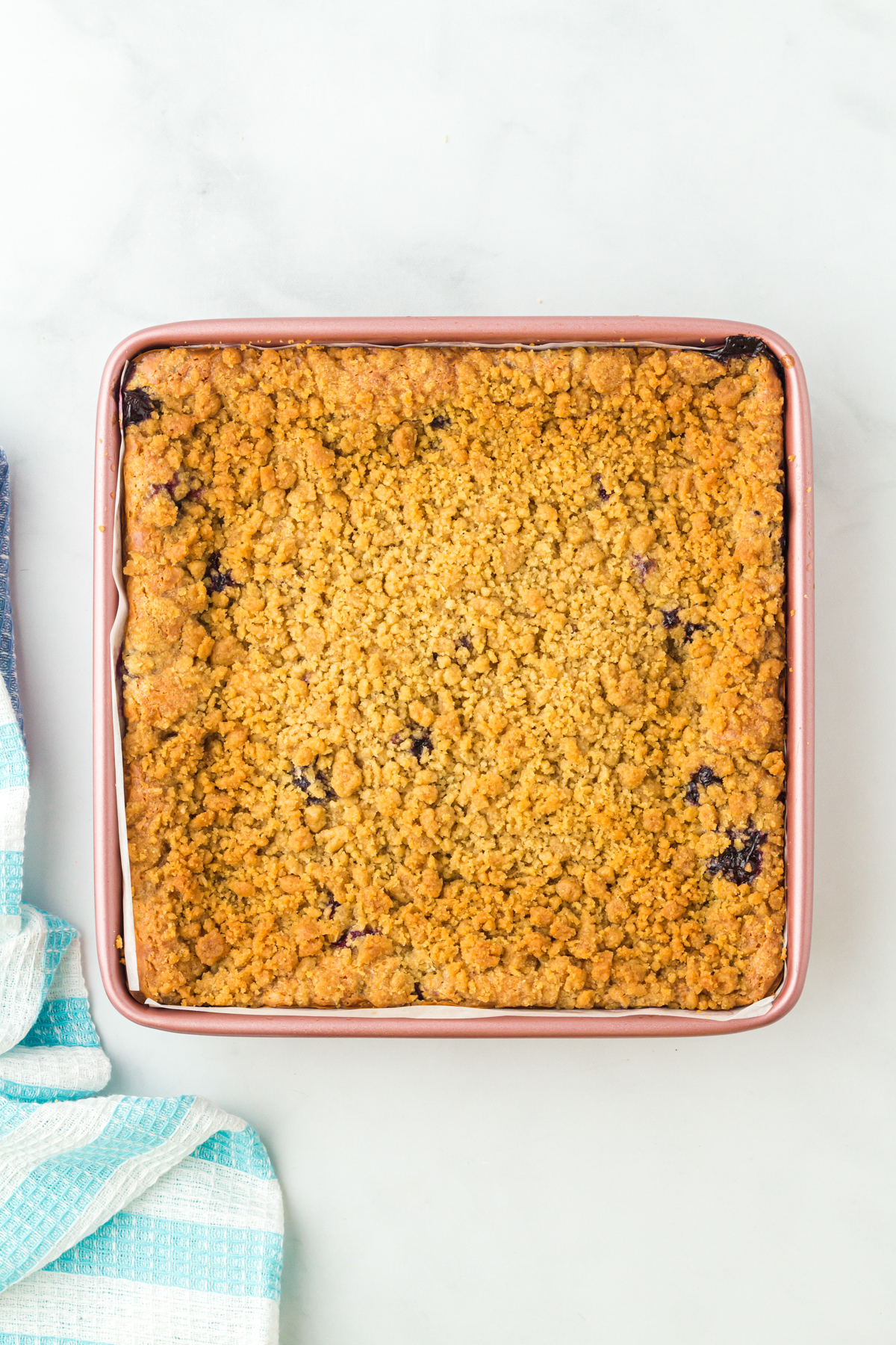 baked blueberry cheesecake bars in a square pan