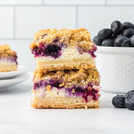 two blueberry cheesecake bars stacked on top of each other