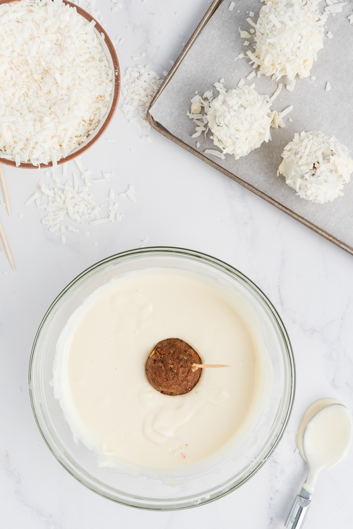 dipping a carrot cake ball in white chocolate