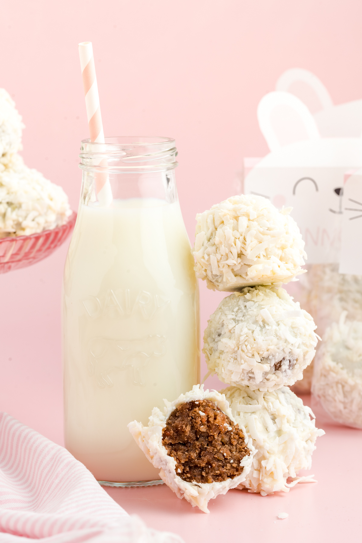 stack of carrot cake balls next to a bottle of milk