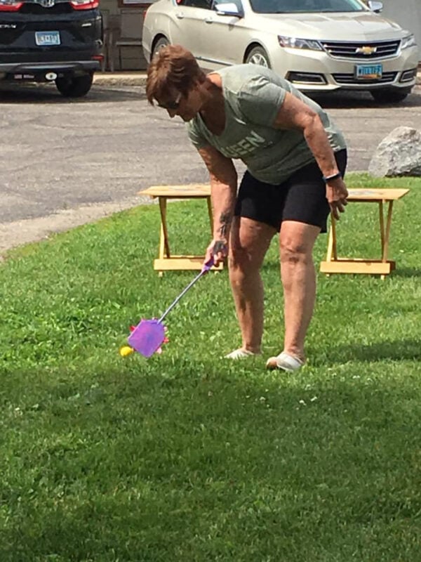 Adult using a fly swatter to play golf