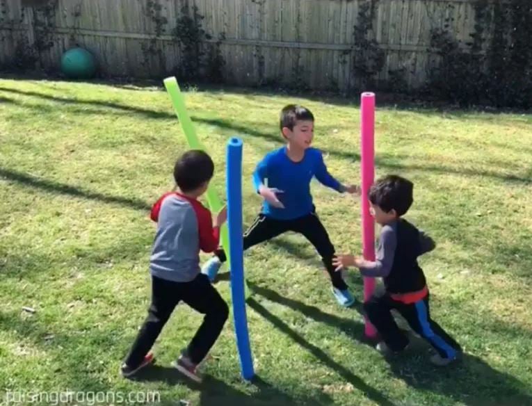 kids standing with pool noodles