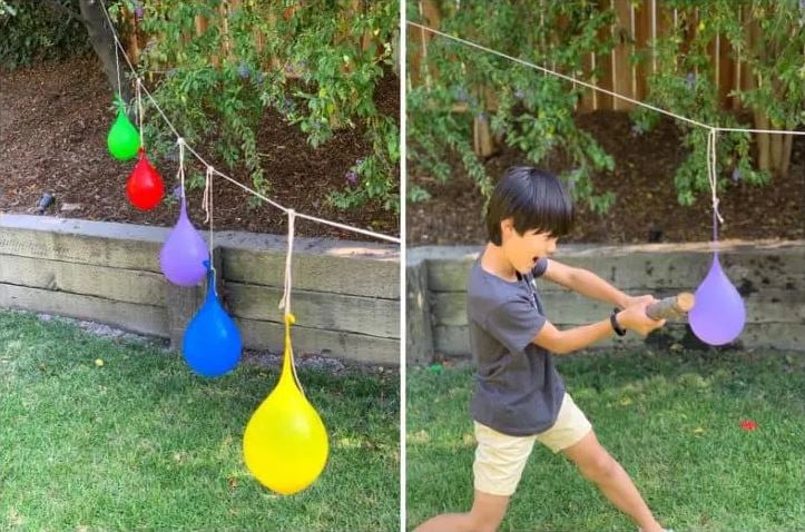 Kid hitting a water balloon hanging on a string