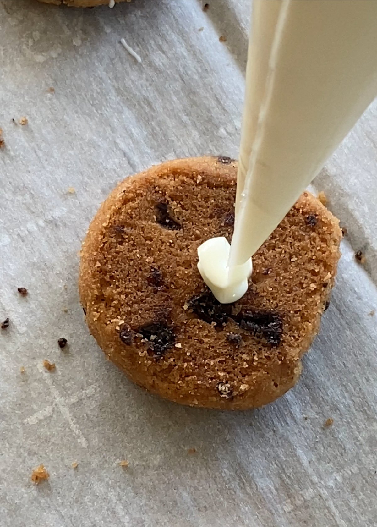 piping white chocolate onto a cookie