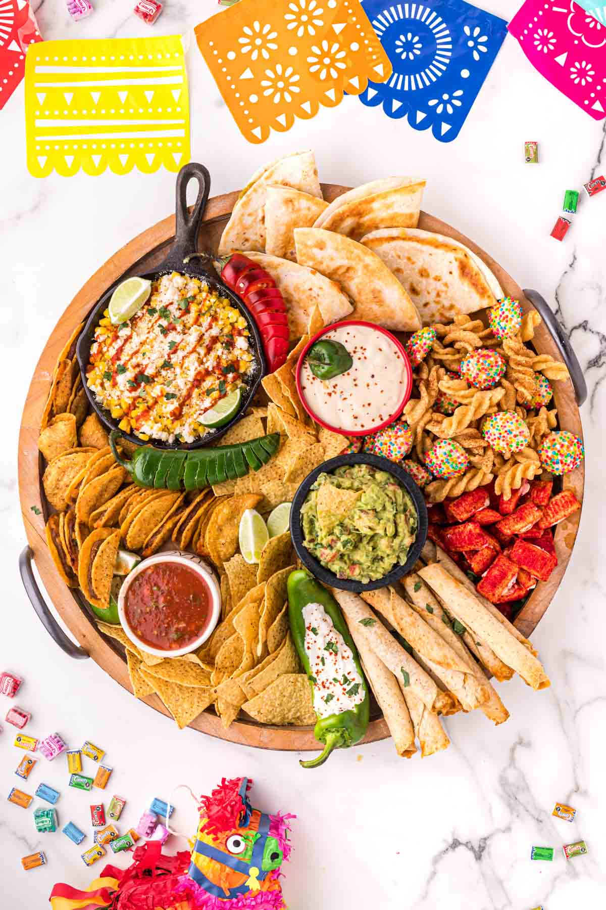Mexican charcuterie board with fiesta flags laying around it
