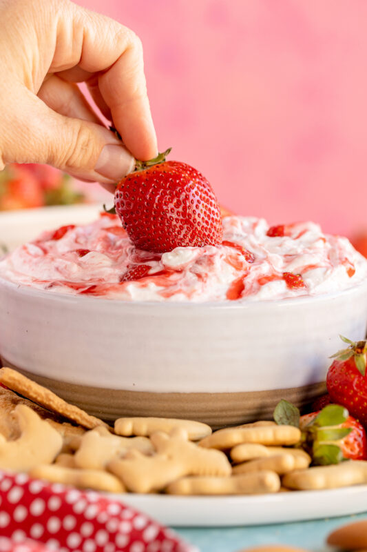 dipping a strawberry into strawberry dip