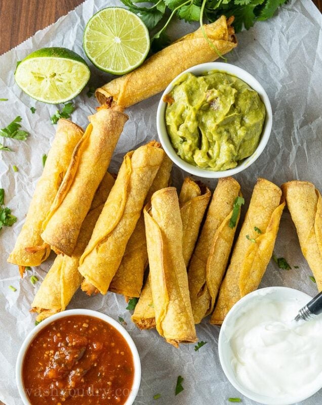 plate of chicken taquitos with guac and salsa