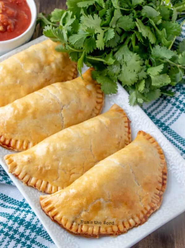 three beef empanadas on a white plate