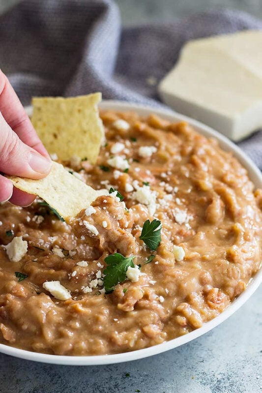 chip dipping into refried bean dip