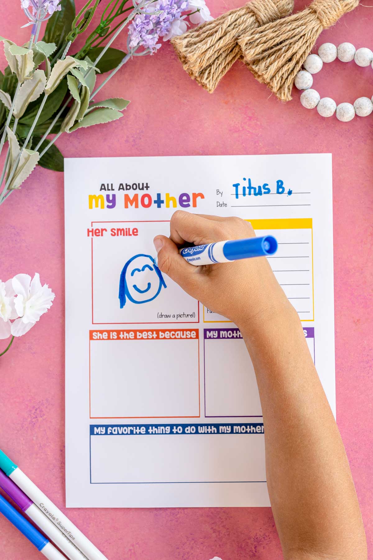 child's hand drawing a picture of their mother