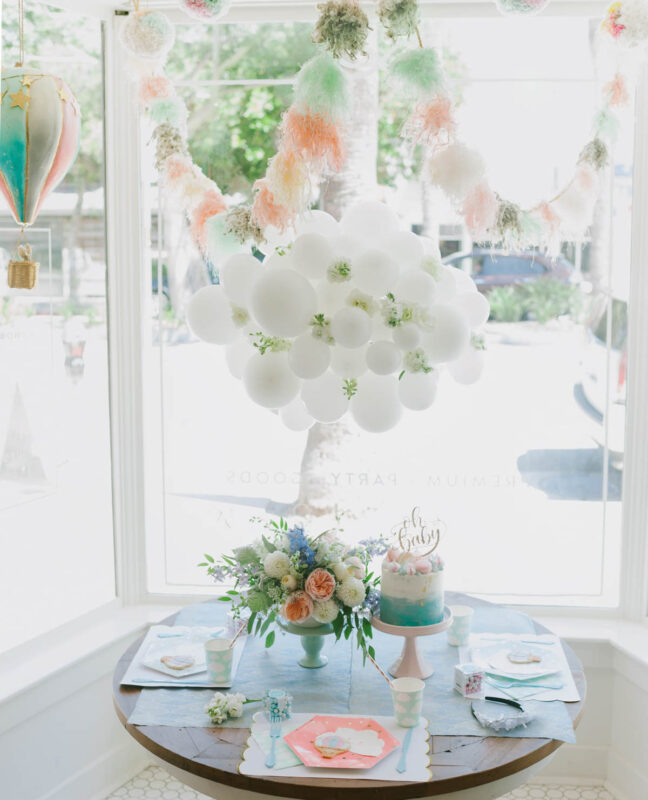 table with white balloons above it