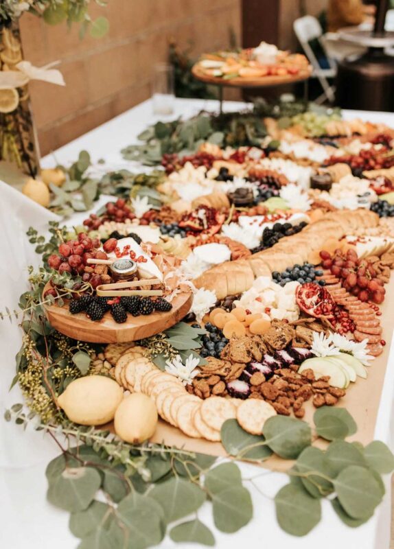charcuterie table with lots of blooming flowers