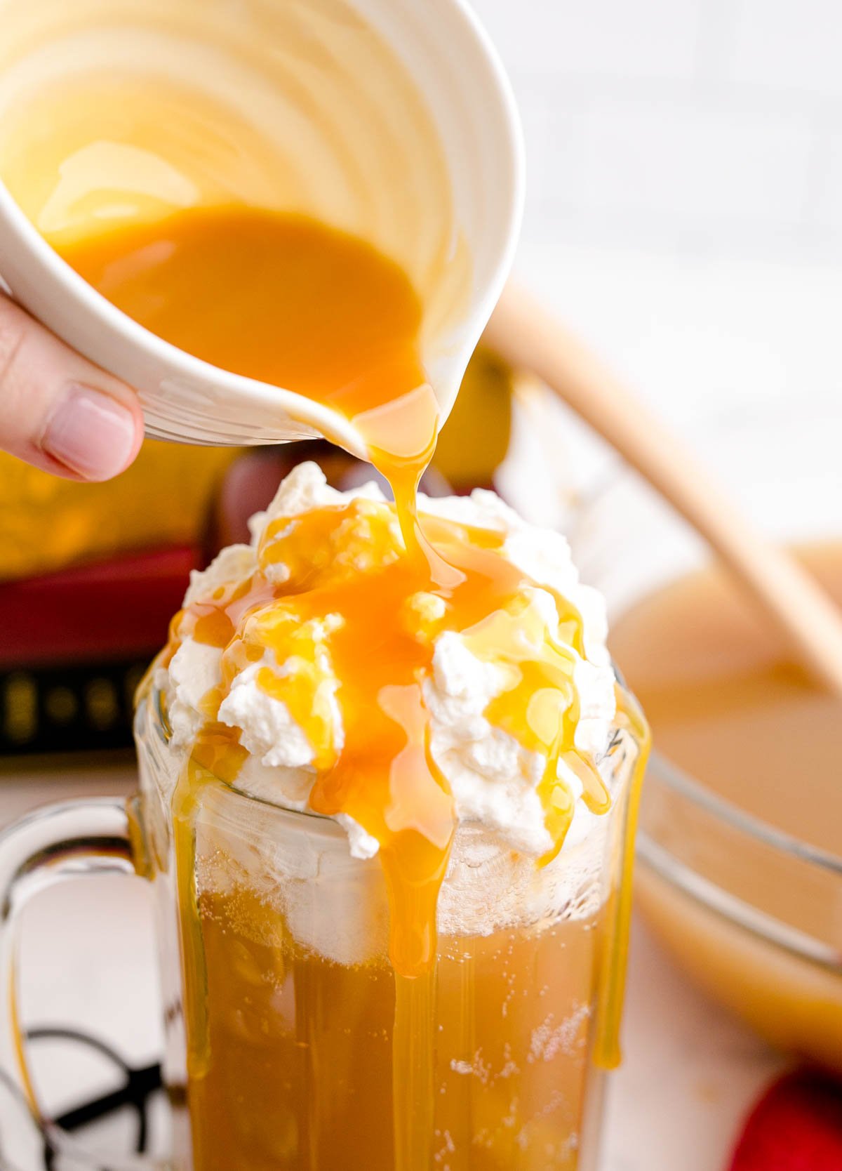 cup pouring butterscotch topping on top