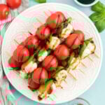 round white plate with caprese salad skewers stacked on it