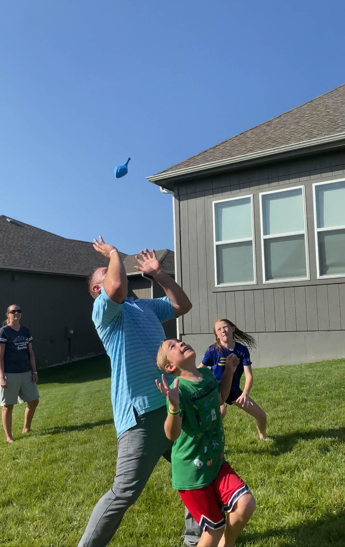 people trying to catch a balloon