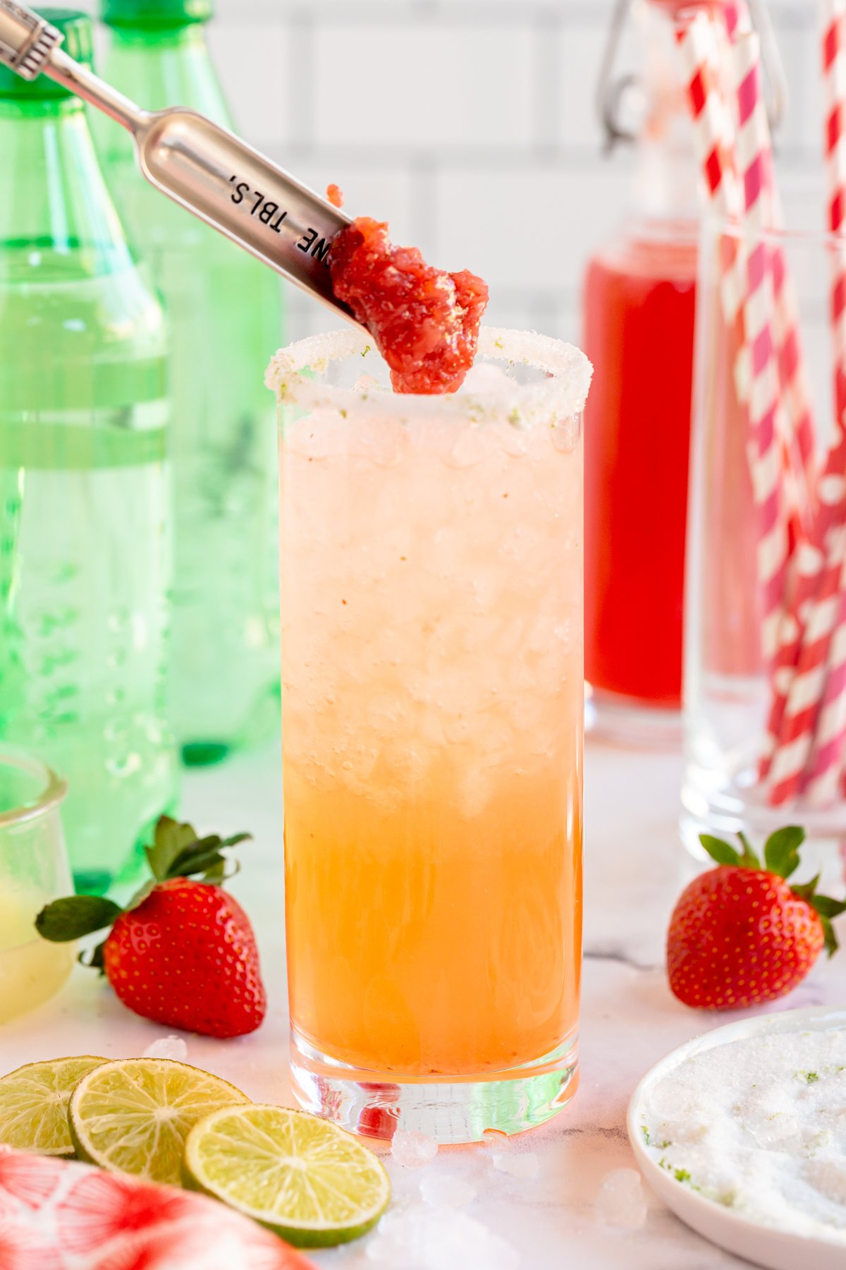 Adding strawberries to a strawberry mocktail