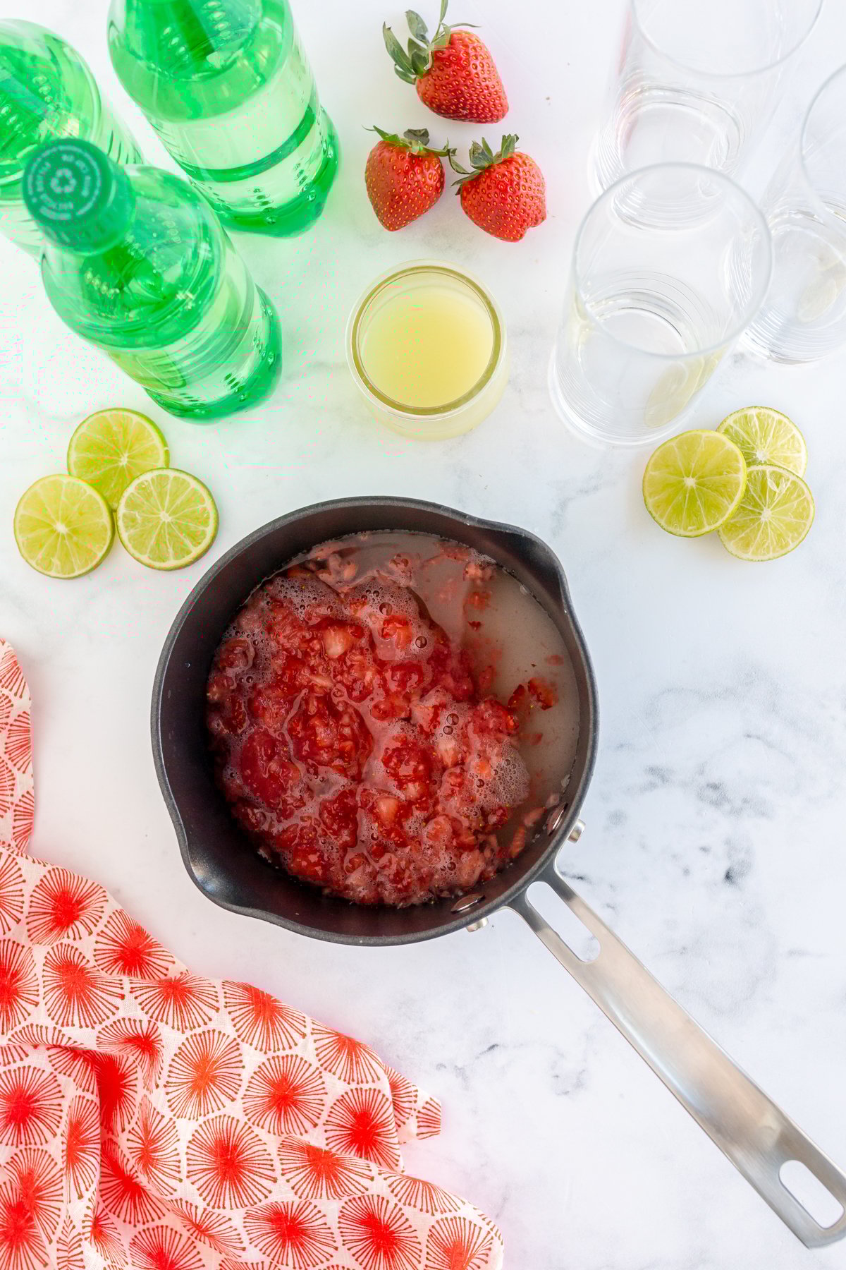 ingredients for a strawberry simple syrup in a pot