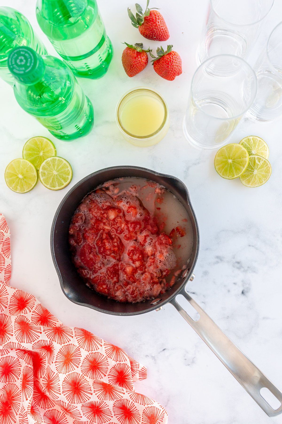 ingredients for a strawberry simple syrup in a pot