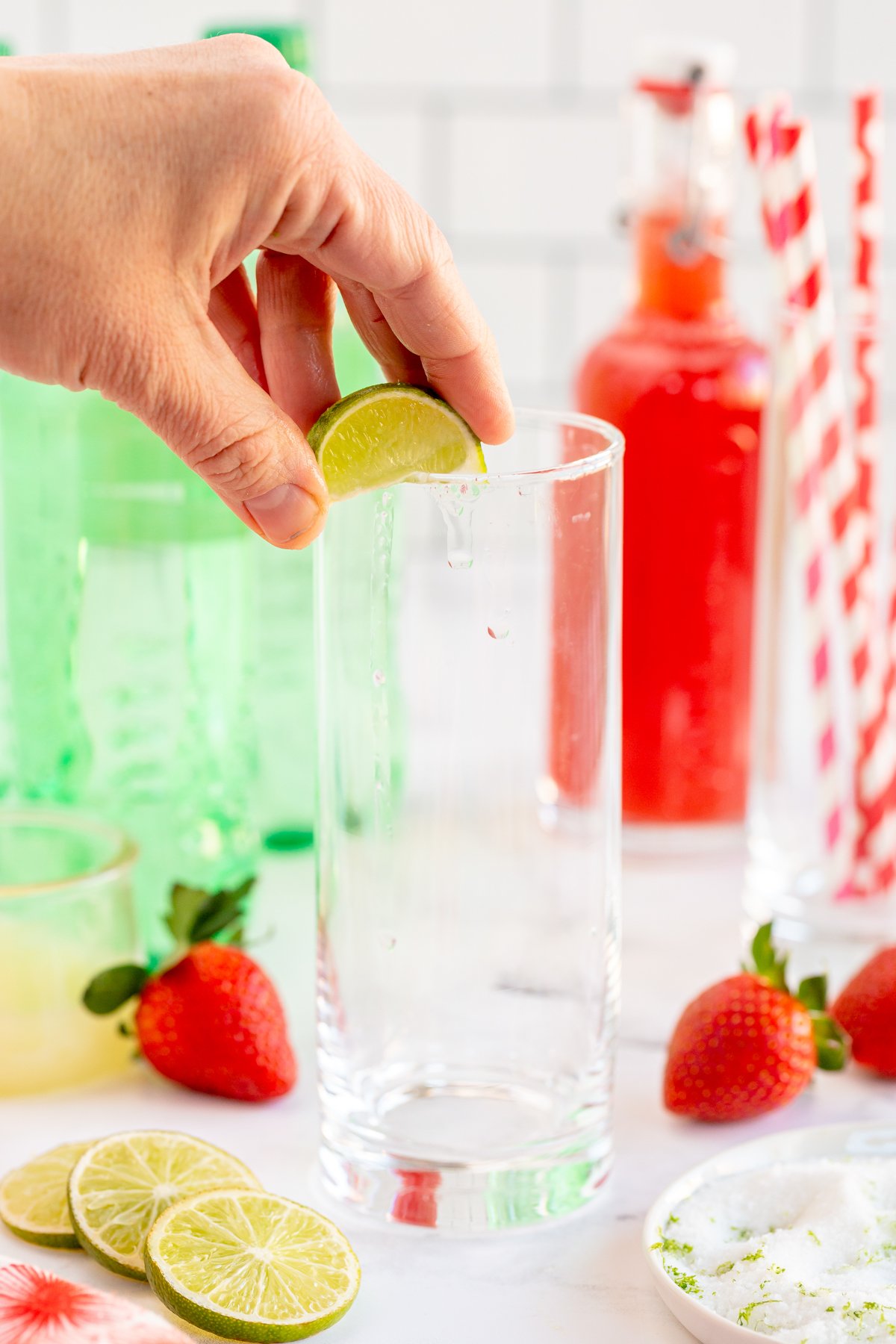 adding a lime wedge to a glass