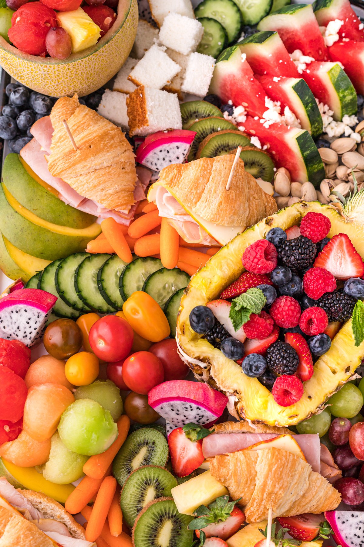 mini croissant sandwiches on a fruit charcuterie board